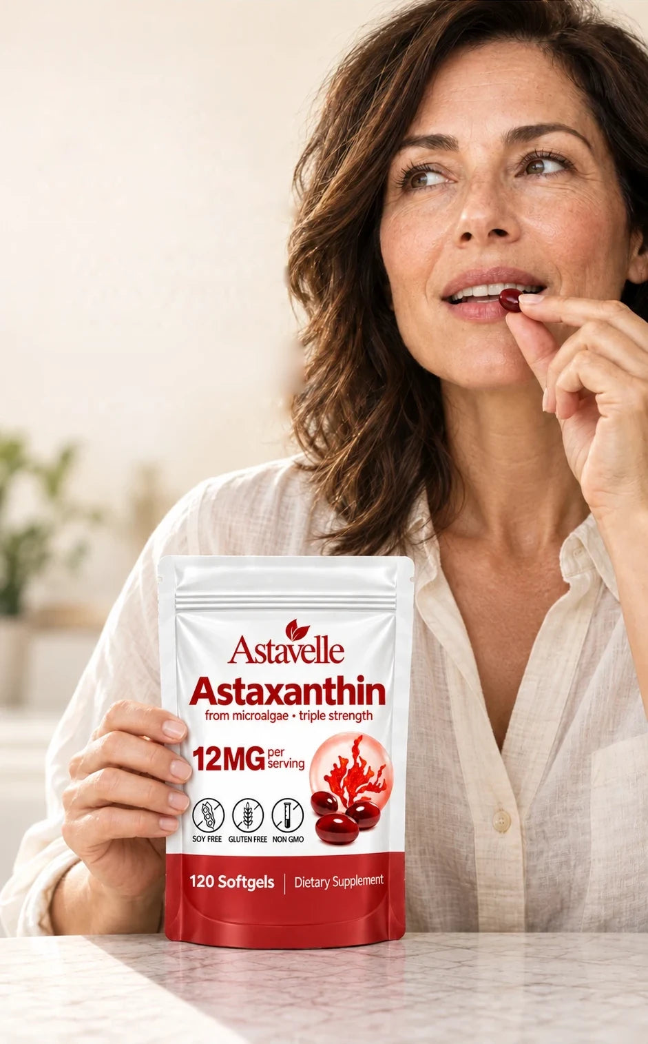 Woman taking an Astavelle softgel, holding the pouch